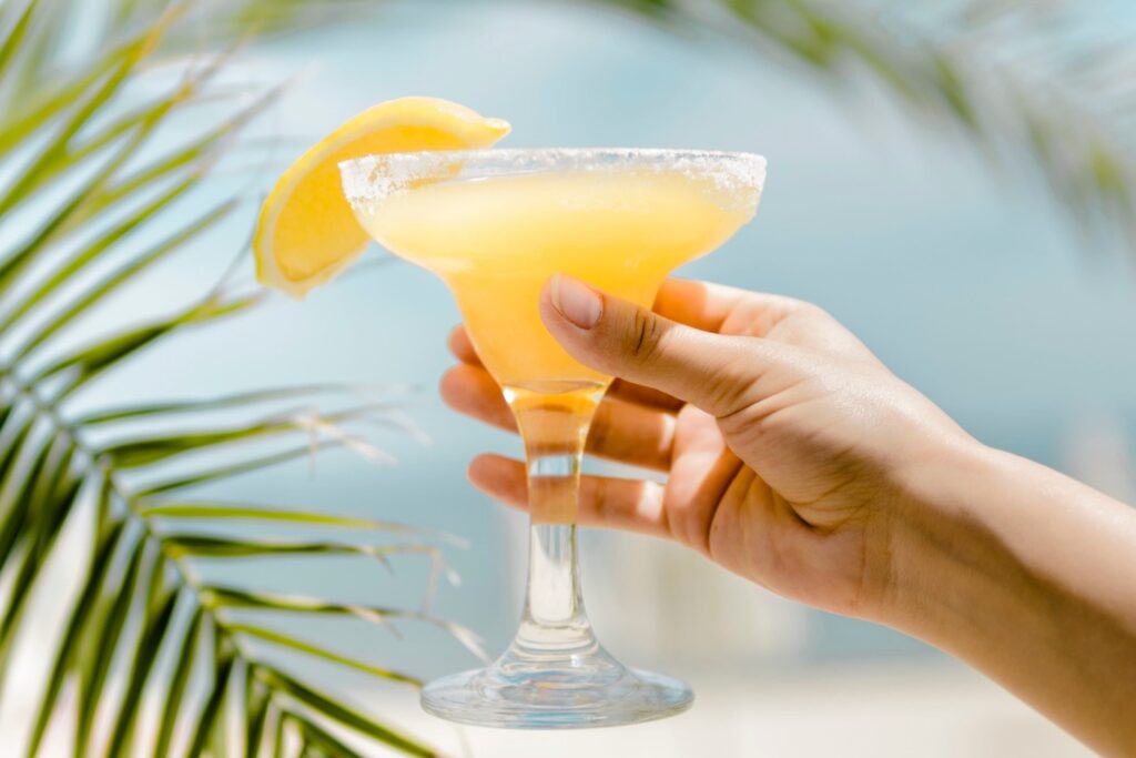 mano-che-tiene-il-bicchiere-da-cocktail-freddo-arancione-con-bevanda-rinfrescante-1