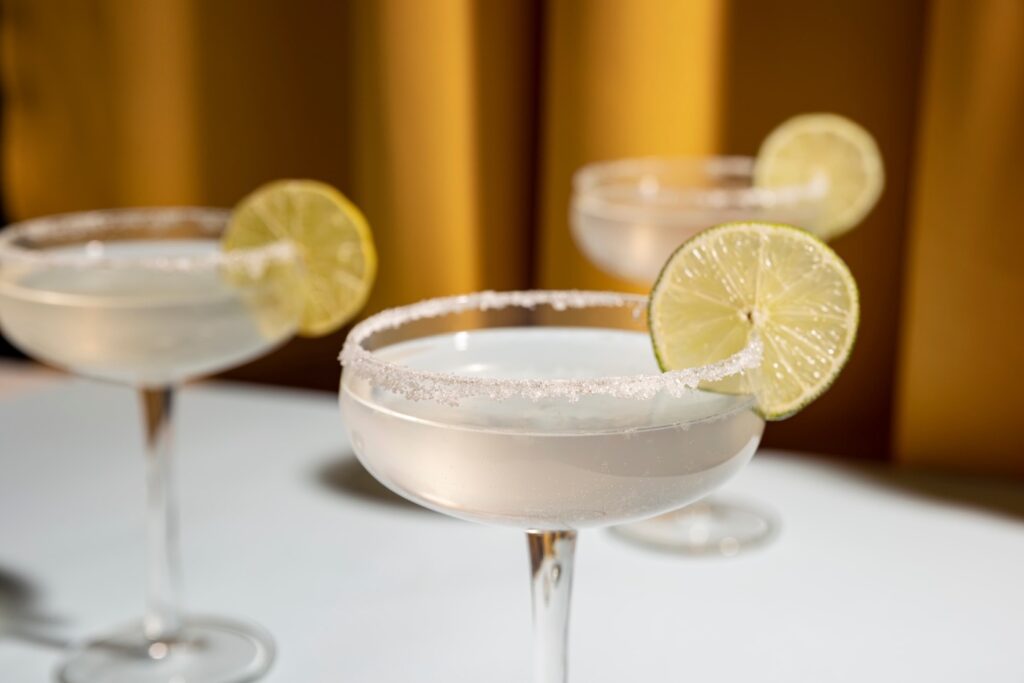 tre bicchieri di piattino di margarita cocktail guarnito con calce sul tavolo